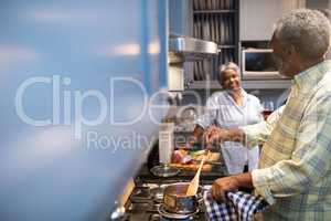 Couple talking while preparing food at home