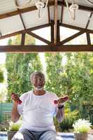 Smiling man exercising under shed at yard