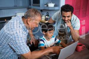 High angle view of father and grandfather looking at boy