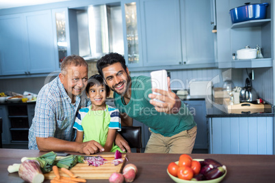 Family taking selfie while preparing food