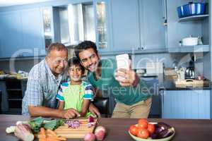 Family taking selfie while preparing food