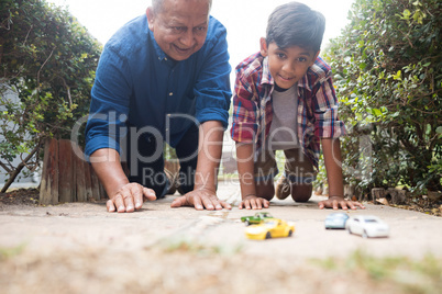 Boy and grandfather playing with toy cars