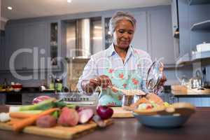 Senior woman preparing food in kitchen