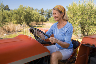 Happy woman sitting in tractor