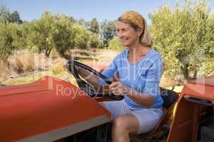 Happy woman sitting in tractor