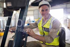 Portrait of happy worker driving forklift