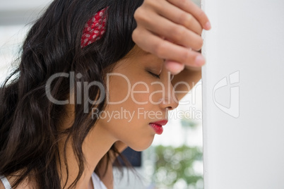 Close up of tensed businesswoman with eyes closed leaning on wall