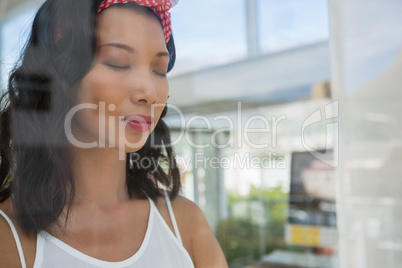Businesswoman with eyes closed seen through glass