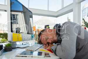 Businessman sleeping at desk in studio