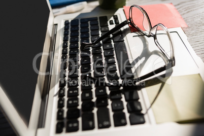 Eyeglasses on laptop computer at table