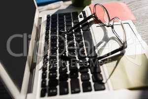 Eyeglasses on laptop computer at table