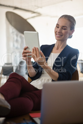 Businesswoman using tablet computer while sitting on chair