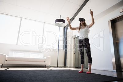 Full length of businesswoman wearing virtual reality simulator