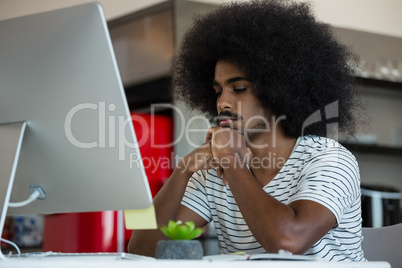 Tired businessman at desk in creative office