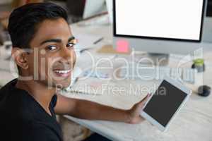 Portrait of man holding digital tablet in office