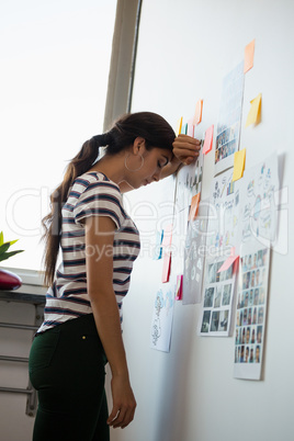 Exhausted woman by sticky notes in office