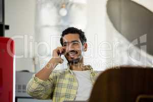 Smiling man talking on phone in office
