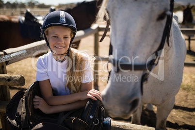 Smiling girl leaning on the fence in ranch