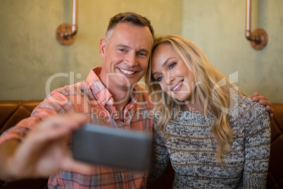 Couple taking selfie on mobile phone in restaurant