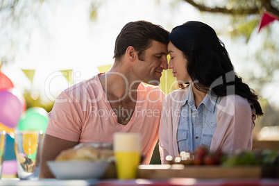 Smiling couple embracing head to head