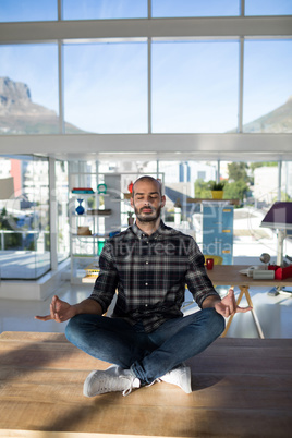 Male executive doing yoga in office