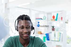 Male executive in headset at his desk in office
