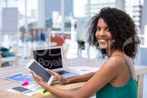 Female executive using digital tablet at desk