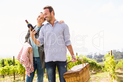 Man with woman holding wine bottle and basket