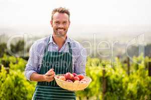 Portrait of smiling man holding apple basket
