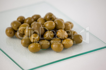 Close up of green olives on glass