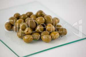 Close up of green olives on glass