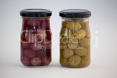 Close up of green and brown olives in jar