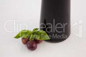 Close up of red olives by oil bottle