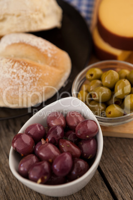 High angle view of olives in bowls by bread