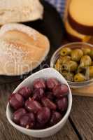 High angle view of olives in bowls by bread