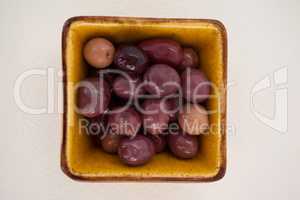 Brown olives in yellow bowl