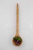 Overhead view of olives with herb in wooden ladle