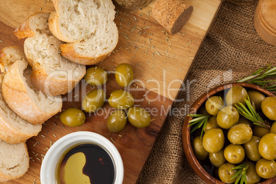 Close up of olives with bread on cutting board