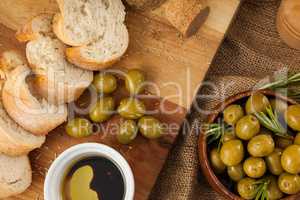 Close up of olives with bread on cutting board