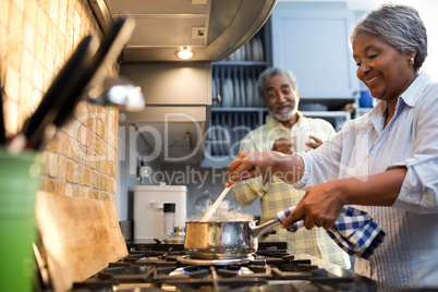 Smiling couple preparing food in kitchen