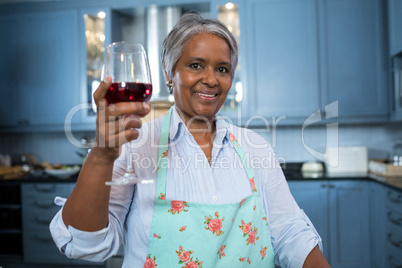 Portrait of woman showing wineglass