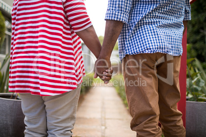 Midsection of senior couple holding hands