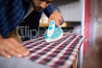 Close up of man ironing shirt