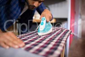 Close up of man ironing shirt