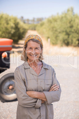 Portrait of happy woman standing with arms crossed in olive farm