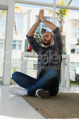 Designer in prayer position meditating at studio
