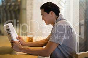 Man reading newspaper in a restaurant