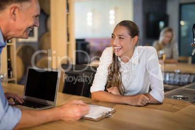 Smiling manager and bartender interacting with each other