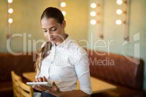 Waitress using digital tablet in bar