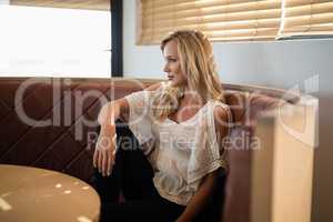 Woman sitting on sofa in restaurant